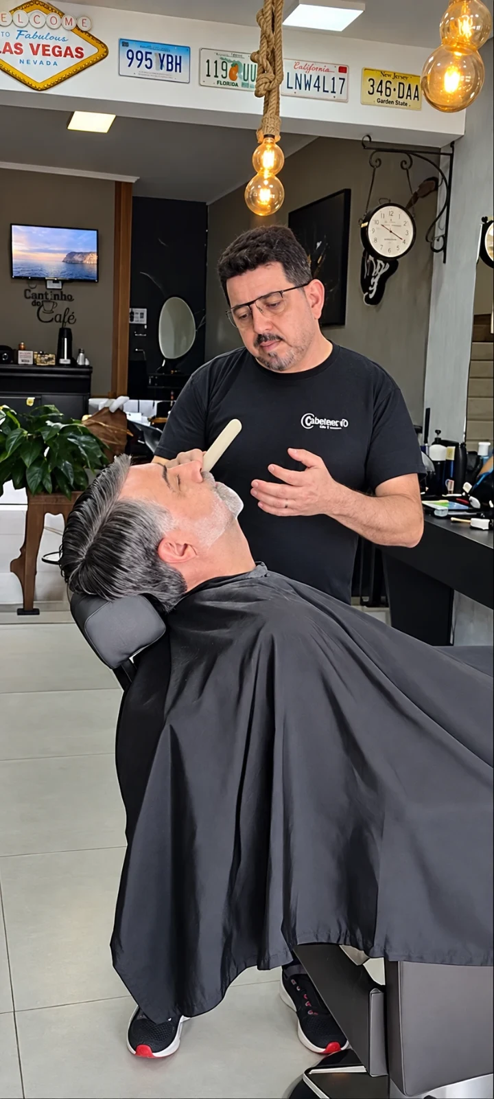 André Moura, fundador da Barbearia AV1, atendendo um cliente