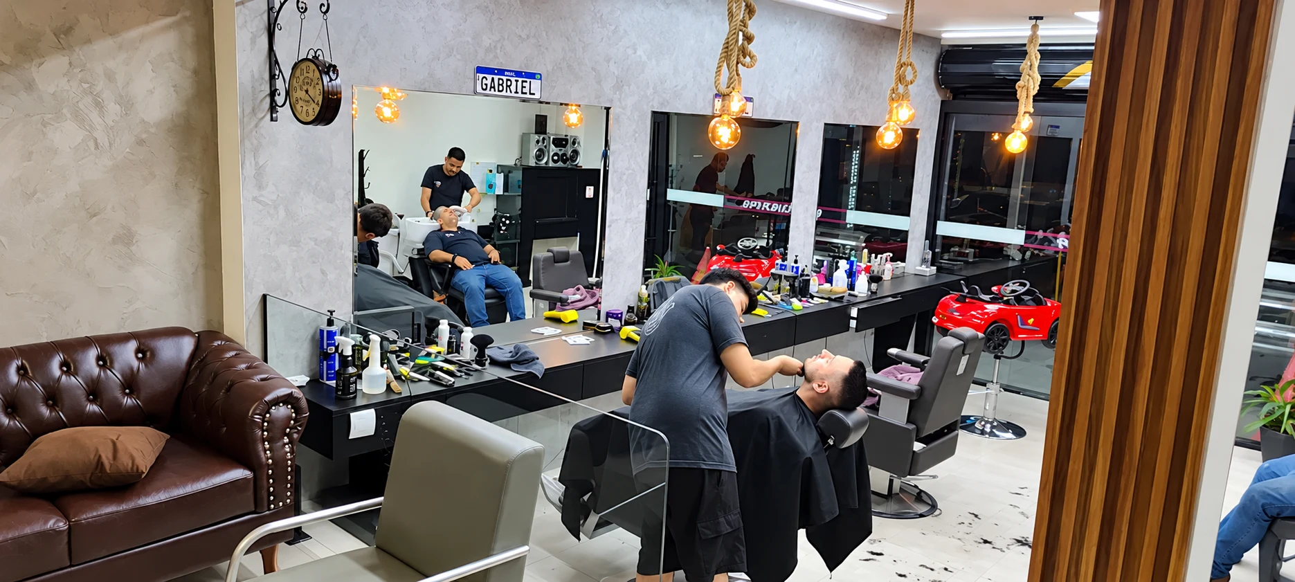 Salão da Barbearia AV1 com cadeiras de barbeiro e espelhos